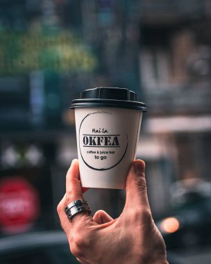 Yerel bir kahve dükkanından kahve kupası alan bir adam.