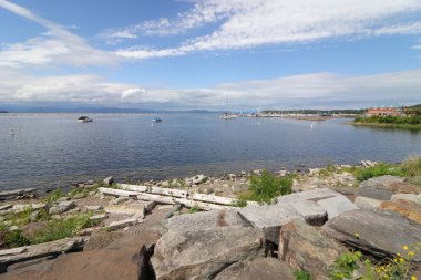 Güneşli bir günde tahta kaldırımdan görünen bulutlu bir gökyüzünün altında güzel bir deniz kıyısı.