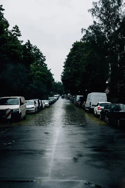 雨天停放在道路两旁的车辆的照片 — 图库照片
