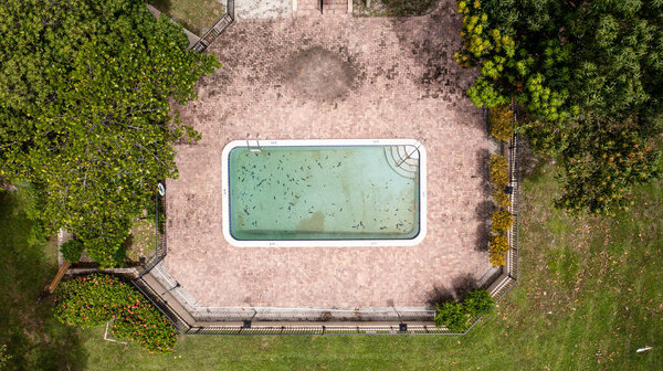 The aerial shot over a swimming pool in an apartment complex on a sunny day in Florida, USA