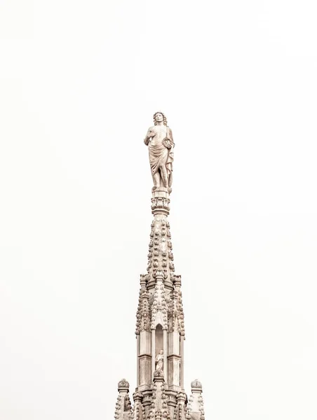 上に女性像のあるミラノ大聖堂の塔の垂直ショット — ストック写真