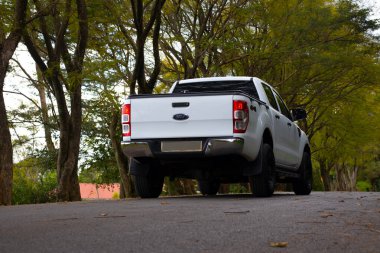 Kırsal bir yolda beyaz modifiye edilmiş bir Ford Ranger 2019 4X4 'ün arka görüntüsü.