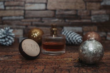 Arka planda kış tatili süslemeleri olan bir parfüm kutusu.