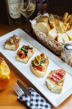 Restoranda beyaz şarapla servis edilen İtalyan yemeği bruschetta 'sının yakın çekimi.