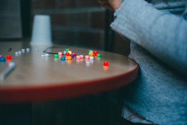 Boncuklarla resim yapan birinin seçici odak noktası.