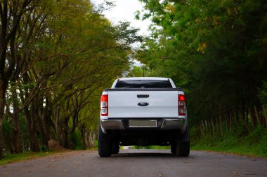 Kırsal bir yolda beyaz modifiye edilmiş bir Ford Ranger 2019 4X4 'ün arka görüntüsü.