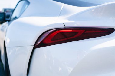 Beyaz bir arabanın arka lambasına yakın çekim.