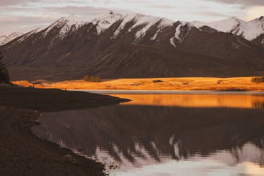 Etrafı dağlarla çevrili güzel bir göl manzarası.