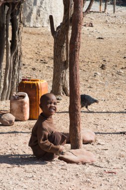 Namibya 'nın dışında oynayan Himba kabilesinden sevimli bir çocuğun dikey çekimi.