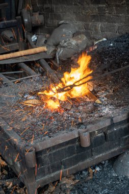 Eski demirci ocağının hava kürkü üfleyen aletleri ve aksesuarlarının dikey çekimi.