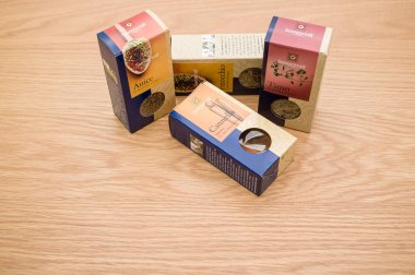 Tahta bir arka planda, metin alanı olan karton paketlerdeki doğal organik bitkiler ve baharatlar.