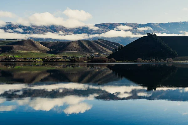 雪に覆われた山に対する湖の写真です — ストック写真