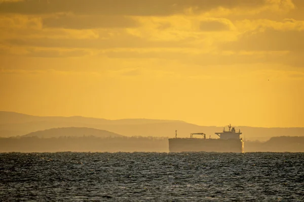 夕方の黄色の空に対する水のボディ上のセーリング船の景色 — ストック写真
