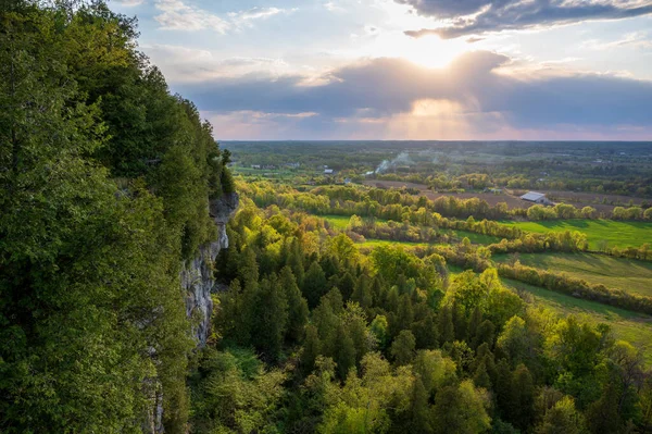 Soleil Plonge Lentement Travers Les Nuages Une Falaise Bordée Arbres — Photo