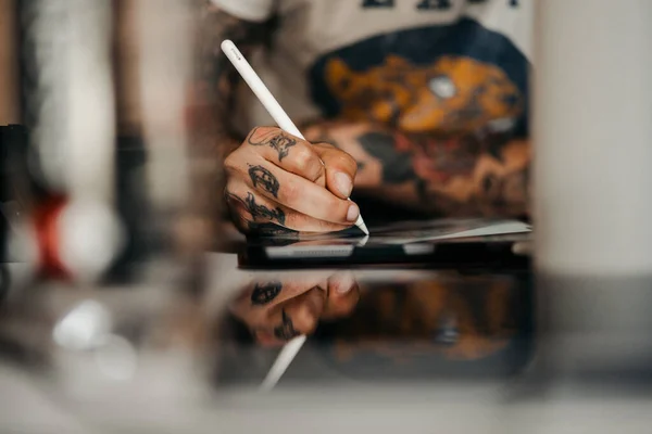 Ipadにステンシルを描くタトゥーアーティストの手のクローズアップショット — ストック写真
