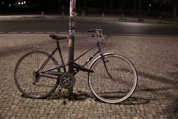 Primo Piano Una Bicicletta Parcheggiata Accanto Una Colonna Strade Notte — Foto Stock