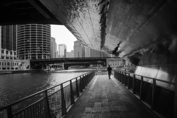 Uma Escala Cinza Homem Correndo Sob Ponte Perto Rio — Fotografia de Stock