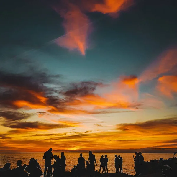 Die Silhouetten Einer Gruppe Junger Freunde Die Sich Bei Sonnenuntergang — Stockfoto