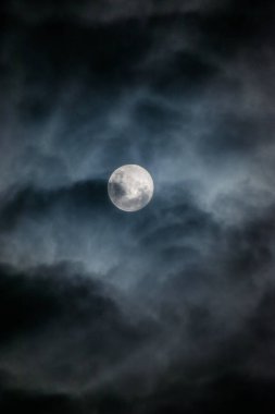 Bulutlu gökyüzünde ayın dikey görüntüsü.