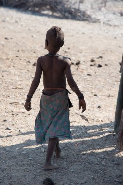 Namibya 'nın dışında oynayan Himba kabilesinden sevimli bir çocuğun dikey çekimi.