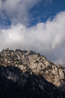 Arka planda bulutlar olan yüksek rakımlı dağların dikey çekimi