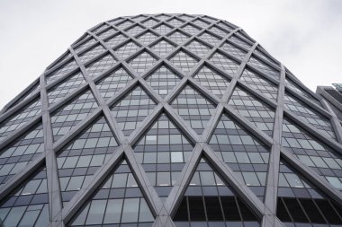 Camlı, simetrik, uzun ve modern bir binanın alçak açılı görüntüsü.