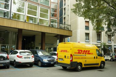 Bir DHL kargo kurye minibüsü nakliye paketleri getiriyor.