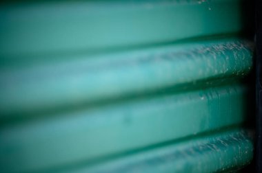 Kirli yeşil depolama kapısı dokusunun seçici odak noktası.