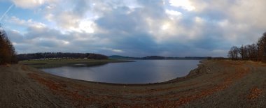 Gölü olan kasvetli kahverengi bir tarlanın panoramik görüntüsü.