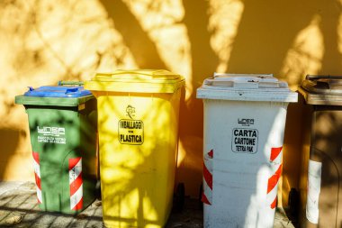 Güneş ışığı altında atık yönetimi için ayrılmış çöp bidonları.