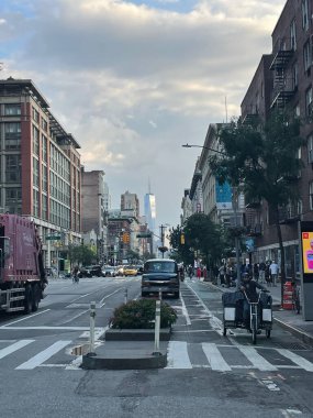 New York 'un güzel bir sokak görüntüsü. Arabalar, araçlar ve binalar bulutlu mavi gökyüzüne karşı.