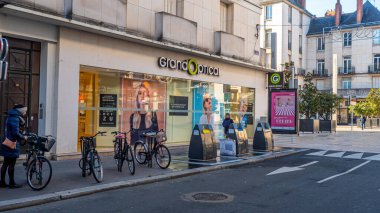 Büyük Optik Optisyen Dükkanı 'nın önünde logo ve tabela ile yürüyen bazı insanlar var..