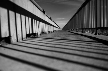 Açık gökyüzünün altındaki bir köprünün gri pulu