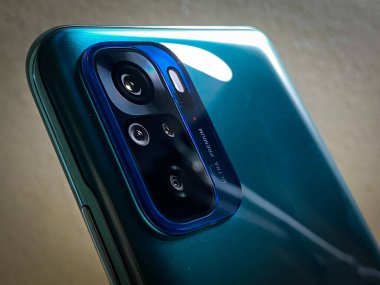 Xiaomi Redmi Note 10 'daki arka kameraların yakın plan görüntüsü. Gölün yeşil renkli ve bulanık arkaplan.