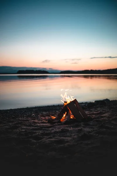 Gün Batımında Gölün Kıyısında Yanan Bir Şenlik Ateşinin Dikey Çekimi — Stok fotoğraf