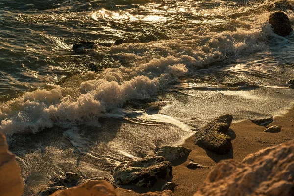 日没時に砂浜に波が打ち寄せる — ストック写真