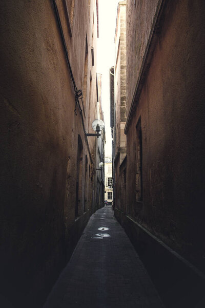 A vertical shot of narrow street between buildings