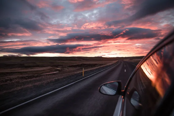アイスランドの風光明媚な夕日の間に道路上の車 — ストック写真