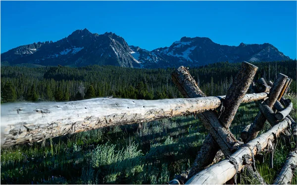 A view of a wooden gate and a mountain under the clear sky