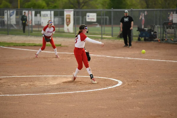 赤と白の制服を着た女の子は 遊び場でチームとソフトボールをプレイ — ストック写真