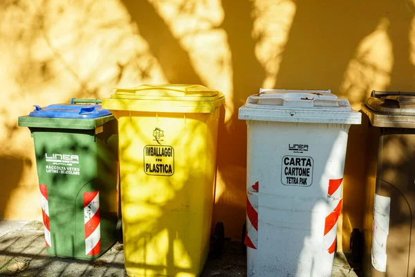 Güneş ışığı altında atık yönetimi için ayrılmış çöp bidonları.