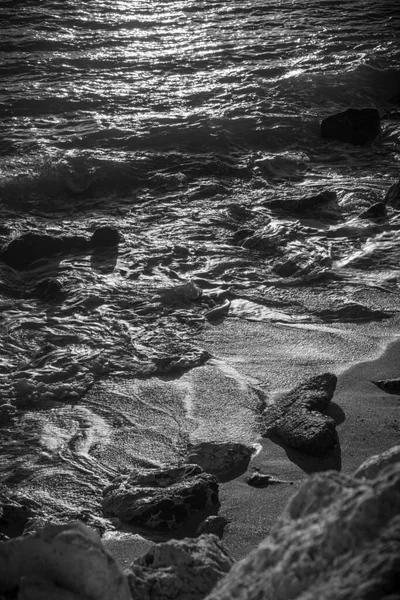 Šedivý Záběr Vln Narážejících Písečnou Pláž Během Západu Slunce — Stock fotografie