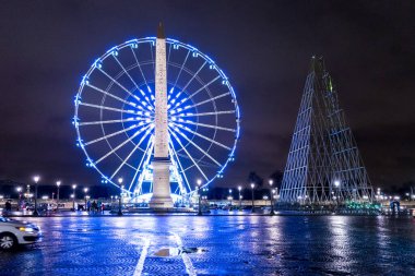 Aydınlatılmış Obelisk anıtı ve gece Paris 'teki dev tekerlek, Champs Elysees.
