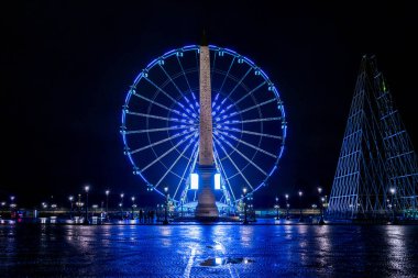 Aydınlatılmış Obelisk anıtı ve gece Paris 'teki dev tekerlek, Champs Elysees.