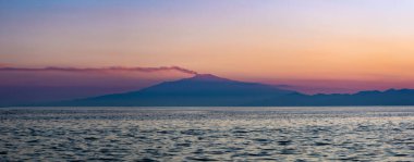 Deniz manzarası ve gün batımında Etna Dağı..