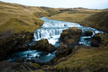 Güney İzlanda 'da güneşli bir günde Skoga Nehri üzerindeki Skogafoss şelalesinin mavi gökyüzüne karşı manzarası