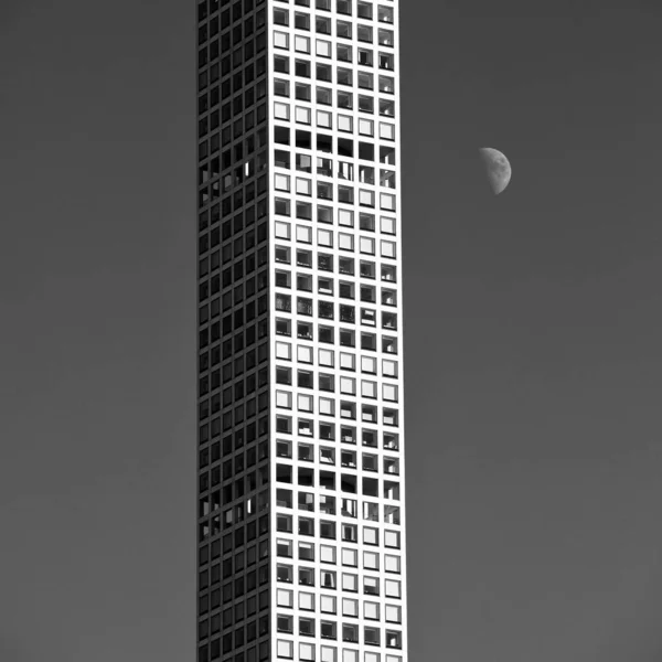 纽约市一座摩天大楼旁边升起的一轮垂直的灰度月亮照片 — 图库照片