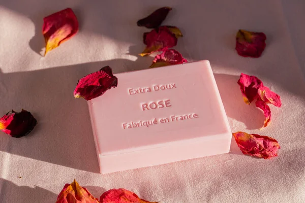 花の花びらに囲まれたバラの香りの正方形の石鹸のクローズアップショット — ストック写真