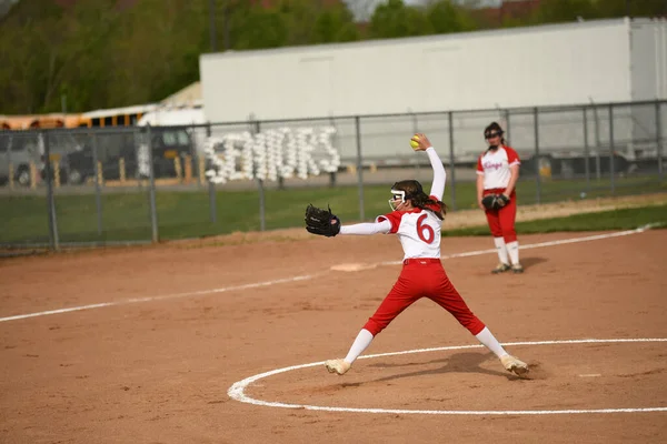 ソフトボールの試合中にボールをキャッチ赤と白の制服の女の子 — ストック写真