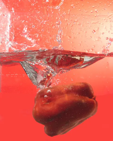 Portrait Capsicum Dunked Water Creates Splash Orange Background — Stock Photo, Image